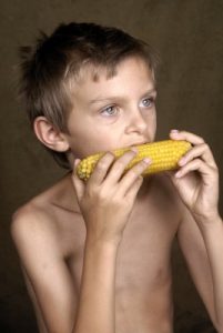 Sick child eating corn